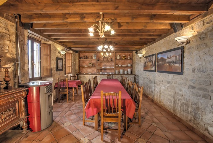 Comedor de La Morada del Cid, con paredes de piedra y techo de madera